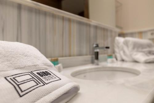 a bathroom with a sink and a towel on a counter at BiBo Suites Real Chancilleria in Granada