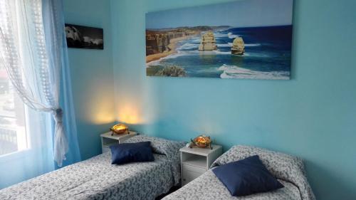 a bedroom with two beds and a painting on the wall at B&B ARCOVEGGIO in Bologna