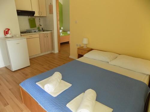 a room with a bed with two towels on it at Apartments Galeb Pag - Beach in Pag