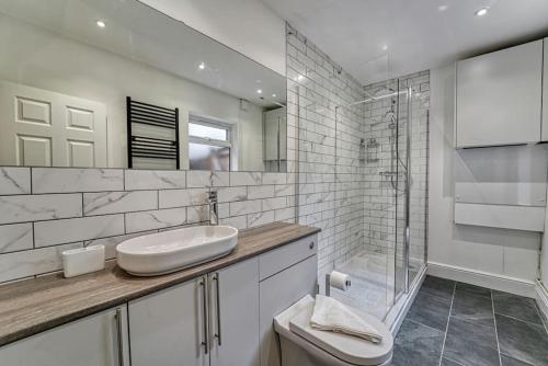 a white bathroom with a sink and a shower at Guest Homes - Droitwich Road Apartment in Worcester