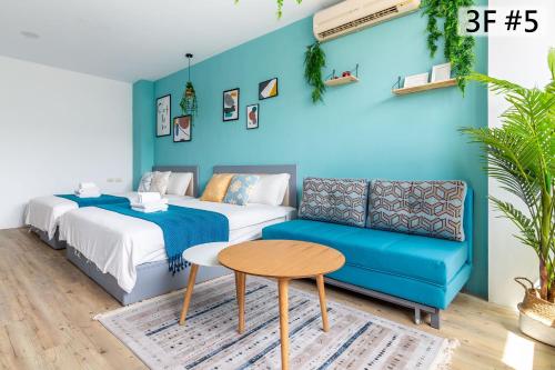 a bedroom with two beds and a blue wall at Sleepier Multi-Minsu Tainan in Tainan