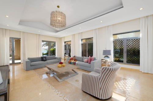 a living room with two couches and a table at Maison Privee - Exclusive Villa with Private Pool, Garden & Beach in Dubai