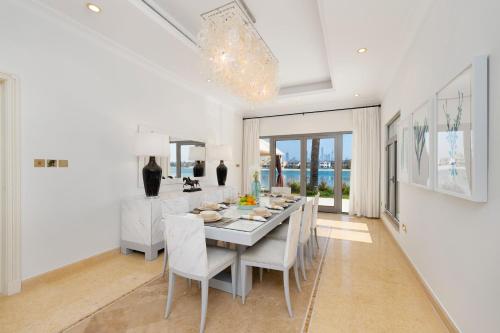 a white dining room with a table and chairs at Maison Privee - Exclusive Villa with Private Pool, Garden & Beach in Dubai