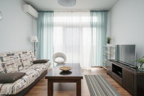 a living room with a couch and a tv at RentPlanet - Apartamenty Zarembowicza II in Wrocław
