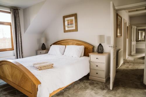 a bedroom with a large bed with a wooden headboard at Valley Lodge Enniskillen in Glenross