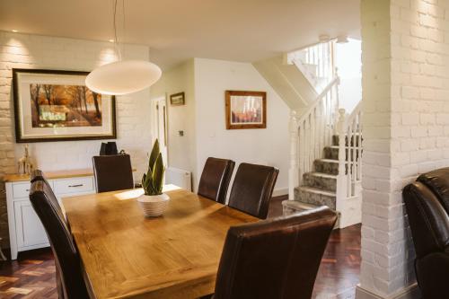 a dining room with a wooden table and chairs at Valley Lodge Enniskillen in Glenross