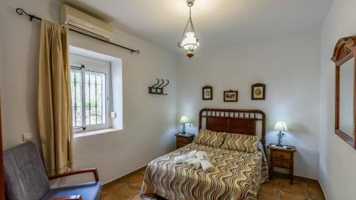 a bedroom with a bed and a window at Cortijo los Valles Alozaina by Ruralidays in Alozaina
