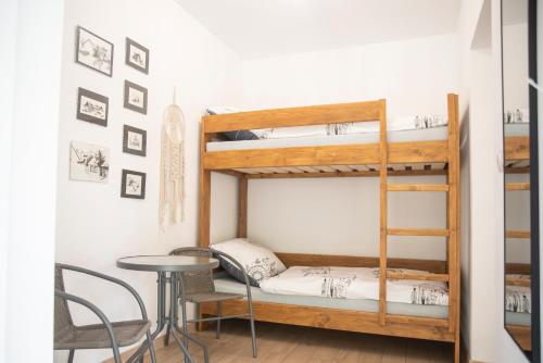 a room with bunk beds and a table and chairs at Dębowe Zacisze in Dębina