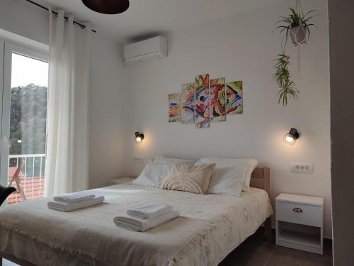 1 dormitorio blanco con 1 cama con 2 toallas en Guest House Vuljan, en Hvar