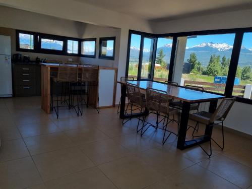 a dining room with a table and chairs and mountains at Casita Trevelin in Trevelin