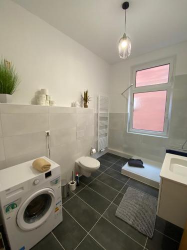 a bathroom with a washing machine and a toilet at RB City Apartments Emden am Wall 2 in Emden