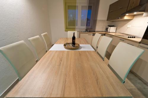 a bottle of wine sitting on a wooden table in a kitchen at Villa Luka with private pool near Pula in Pula