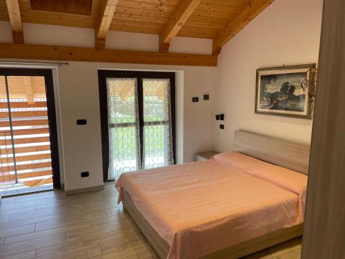 een slaapkamer met een bed en een groot raam bij Camera con vista Castello in Pavone Canavese