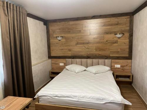 a bedroom with a bed with a wooden wall at Fortetsya in Khmelʼnytsʼkyy