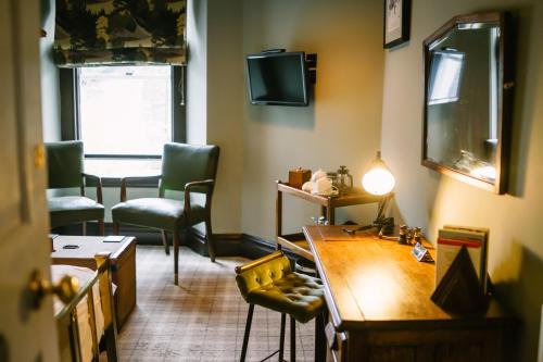 a room with a desk and two chairs and a television at Rum Doodle, Windermere B&B in Windermere