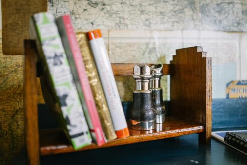 a wooden shelf with books and a pepper shaker at Rum Doodle, Windermere B&B in Windermere