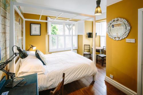 a bedroom with a bed and a desk and a window at Rum Doodle, Windermere B&B in Windermere