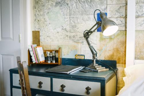 a desk with a lamp on top of a dresser at Rum Doodle, Windermere B&B in Windermere