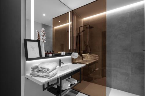 a bathroom with a sink and a mirror at THE MANES Boutique Hotel Prague in Prague