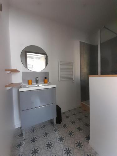 een badkamer met een wastafel en een spiegel bij La pause sous le pin in Capestang