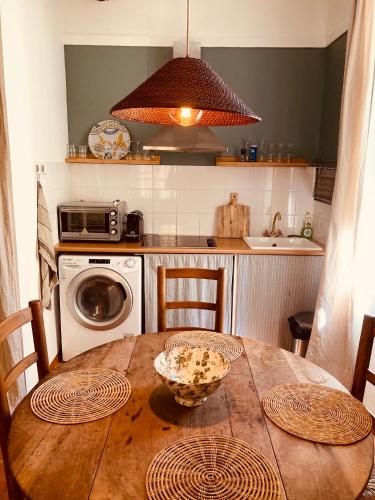 une cuisine avec une table en bois et un micro-ondes dans l'établissement Appartement de charme au coeur du vieux Aix., à Aix-en-Provence