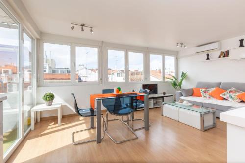 sala de estar con mesa y sofá en Apartamento Ático Las letras, en Madrid