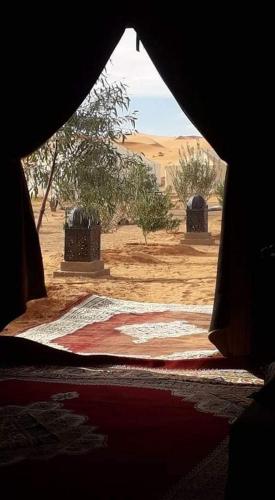 a view of the desert from a window of a tent at Khadija Desert Camp in Merzouga