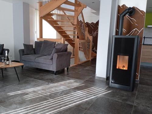 a living room with a fireplace and a couch at Le gîte des Kritter in Stosswihr