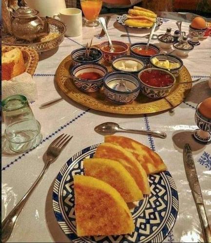 a table with plates of bread and bowls of sauce at Khadija Desert Camp in Merzouga
