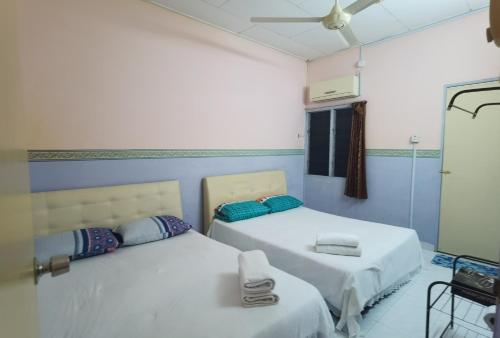 a room with two beds and a mirror at RnC T1 in Ipoh