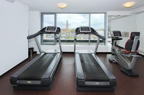 a gym with two tread machines and a window at ARCOTEL Rubin Hamburg in Hamburg