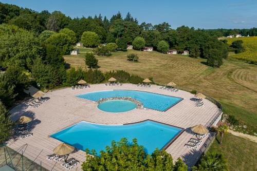 an overhead view of a swimming pool with chairs and umbrellas at La Forêt Enchantée in Cornille