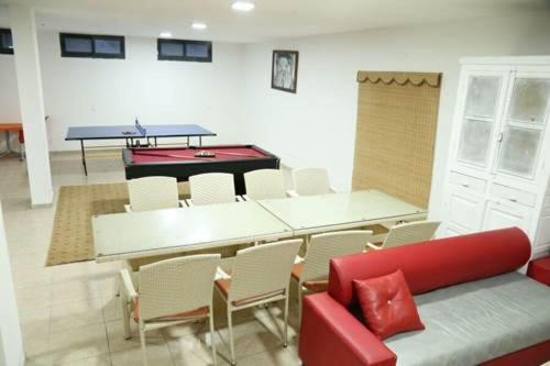 - un salon avec une table de ping-pong et des chaises dans l'établissement Aseel hostel, à Majdal Shams
