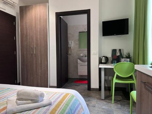 1 dormitorio con 1 cama y escritorio con silla verde en Bnbook Residence Matteotti, en Novara