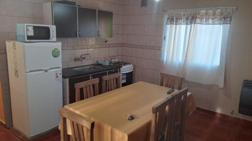 cocina con mesa y nevera blanca en Departamento "MI SUEÑO" en San Juan