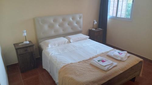 1 dormitorio con 1 cama con 2 toallas en Departamento "MI SUEÑO" en San Juan