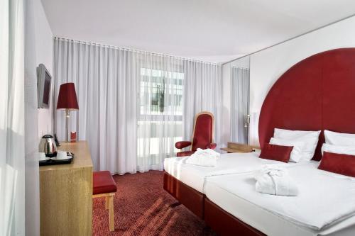 a hotel room with two beds and a chair at ARCOTEL Rubin - im Szeneviertel St Georg in Hamburg