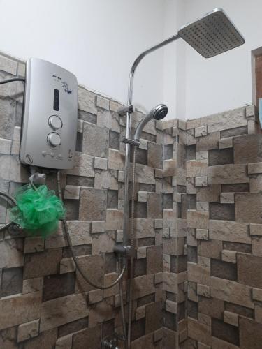 a shower in a bathroom with a stone wall at Kingdom of Haven in Ahangama