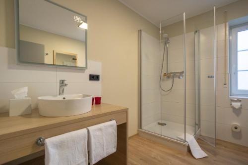 a bathroom with a sink and a shower at Der Stahlberg Hotel & Restaurant in Hilchenbach