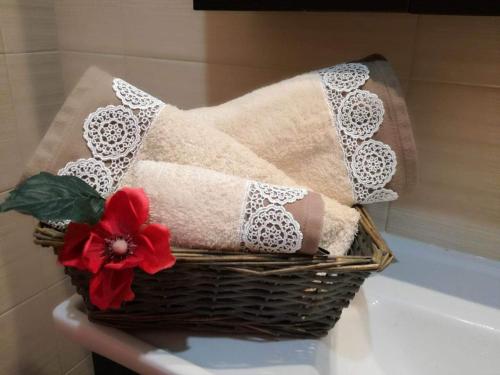 a basket with towels and a red flower on a bath tub at VISTA DI MARE 3 in Lixouri