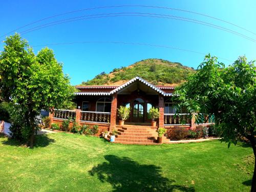ein Haus mit einem Berg im Hintergrund in der Unterkunft Sai Leela Bungalow - Villa with Private Pool in Mahabaleshwar