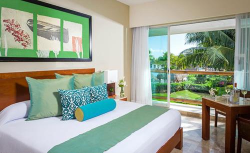 a bedroom with a large bed and a large window at Resort Vidanta Riviera Maya in Puerto Morelos