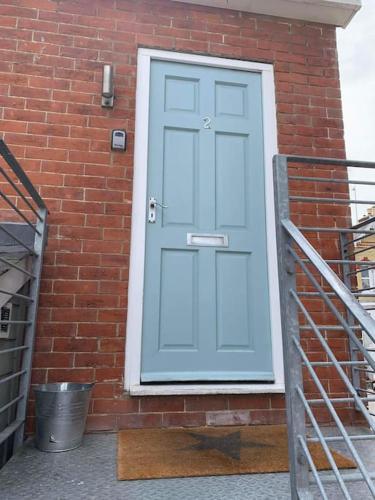 a blue door on the side of a brick building at Flat2BeckfordMews in Cowes
