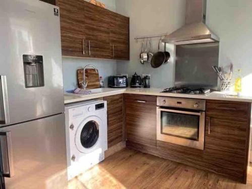 a kitchen with a washing machine and a washer at Flat2BeckfordMews in Cowes