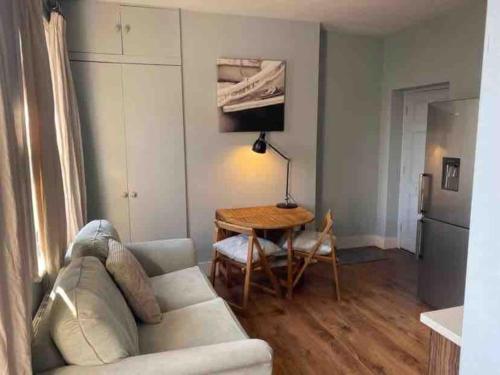 a living room with a couch and a table at Flat2BeckfordMews in Cowes