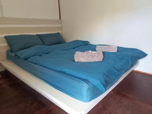 ein Bett mit blauer Bettwäsche und zwei Handtüchern darauf in der Unterkunft Tiongman Scubadive & Lodge in Tioman Island