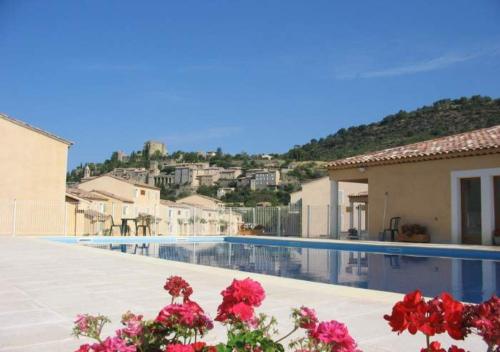 una villa con piscina e fiori rossi di Olydea Montbrun-les-Bains a Montbrun-les-Bains