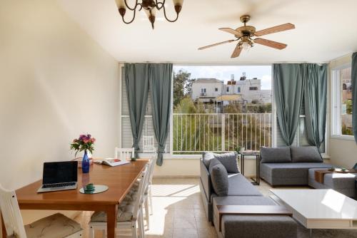 a living room with a table and a couch at Gordon Seaside 4BDR apt in TLV in Tel Aviv