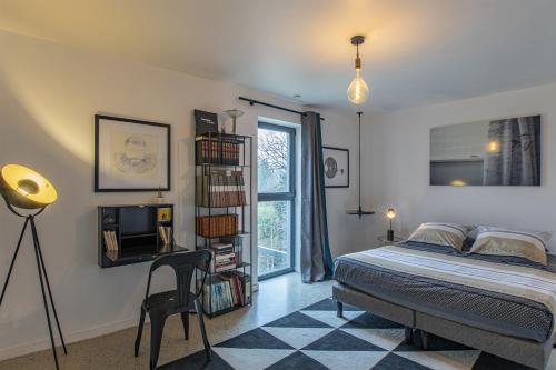 1 dormitorio con cama y estante para libros en La Conserverie, en Blois