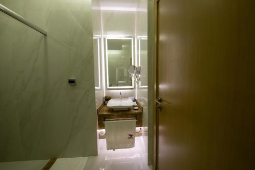 a bathroom with a sink and a toilet and a mirror at Redwaves Hotel in Jeddah